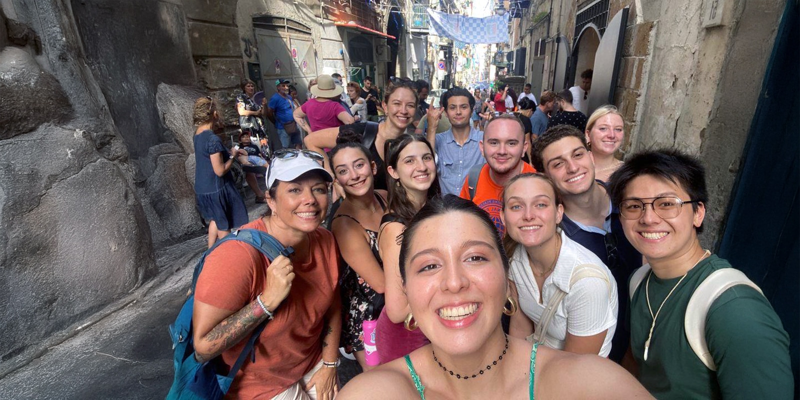 Group of UF students smiling for a selfie while exploring a historic street abroad