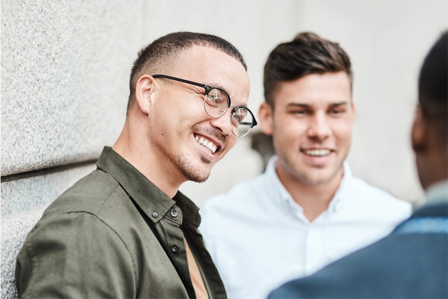 Group of young professionals smiling and talking outdoors