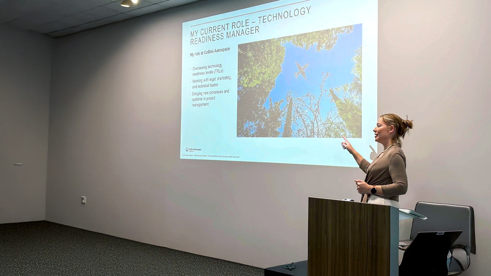 Speaker pointing at a presentation.
