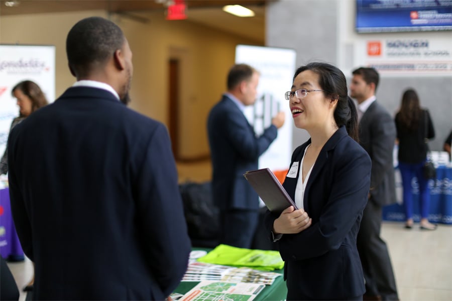 Business student speaks with recruiter at a career fair hosted inside Warrington College of Business
