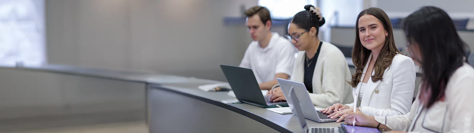 A smiling female student in a classroom group.