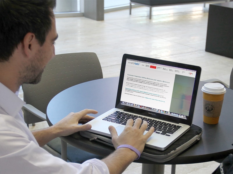 Graduate student sitting at a table on his computer with WebLab open.