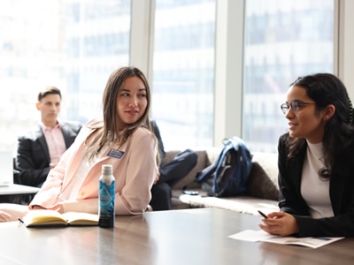 FinTech track students meet at a table to discuss finance.