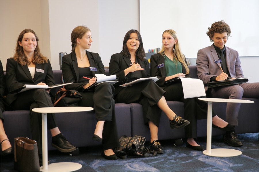 UF business students in professional attire engage in a collaborative discussion session