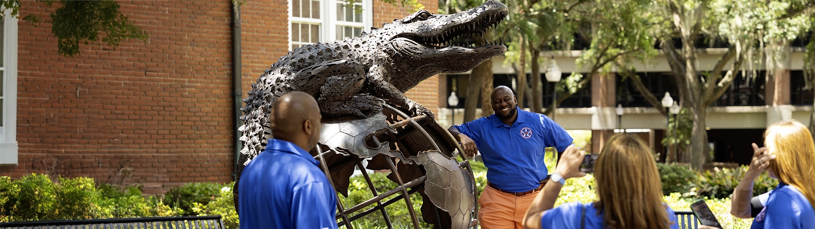 A Veterans Entrepreneurship Program attendee poses for a photo with the Gator Ubiquity statue on UF's campus. 