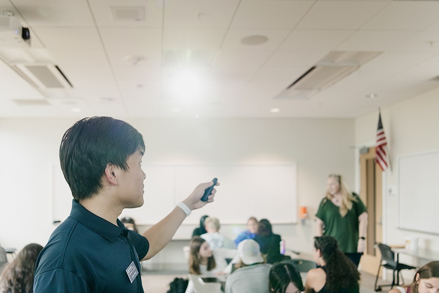 Student pointing a remote. 