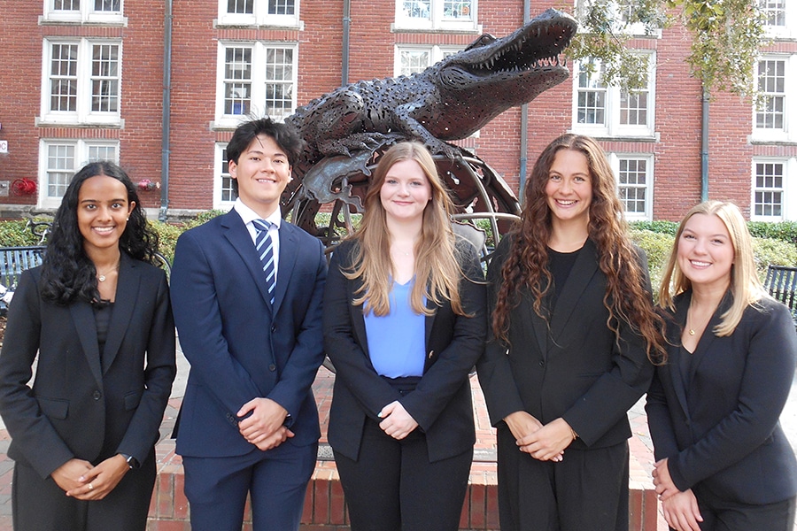 Business Ethics Case Competition Team posing in front of the Gator Ubiquity Statue. 