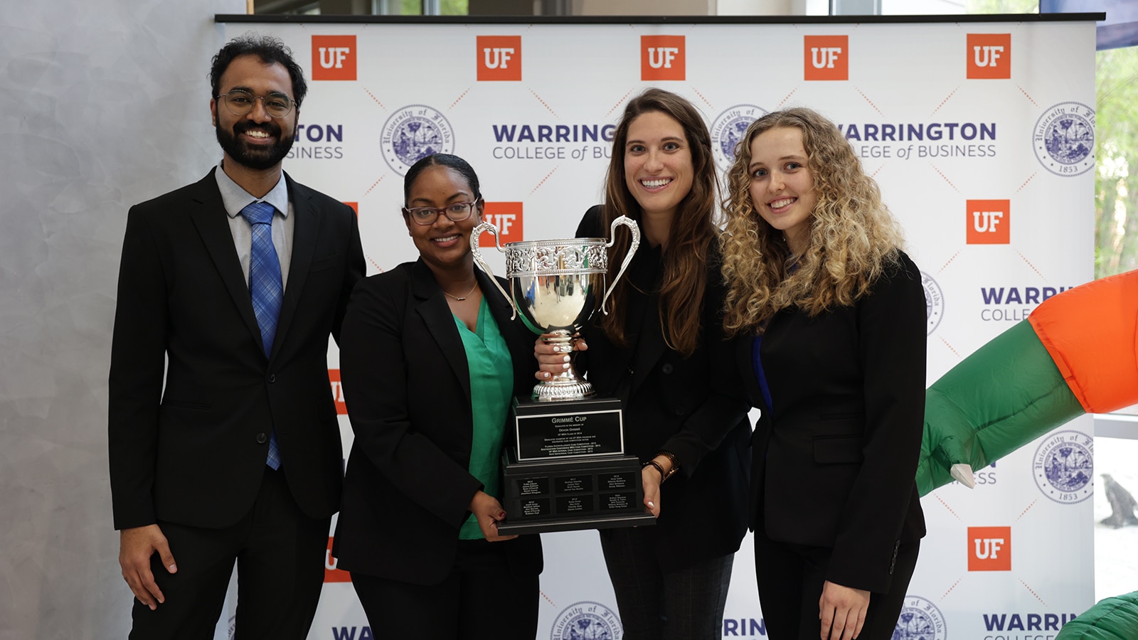 University of Florida Full-Time MBA students holding a trophy after winning a case competition. 