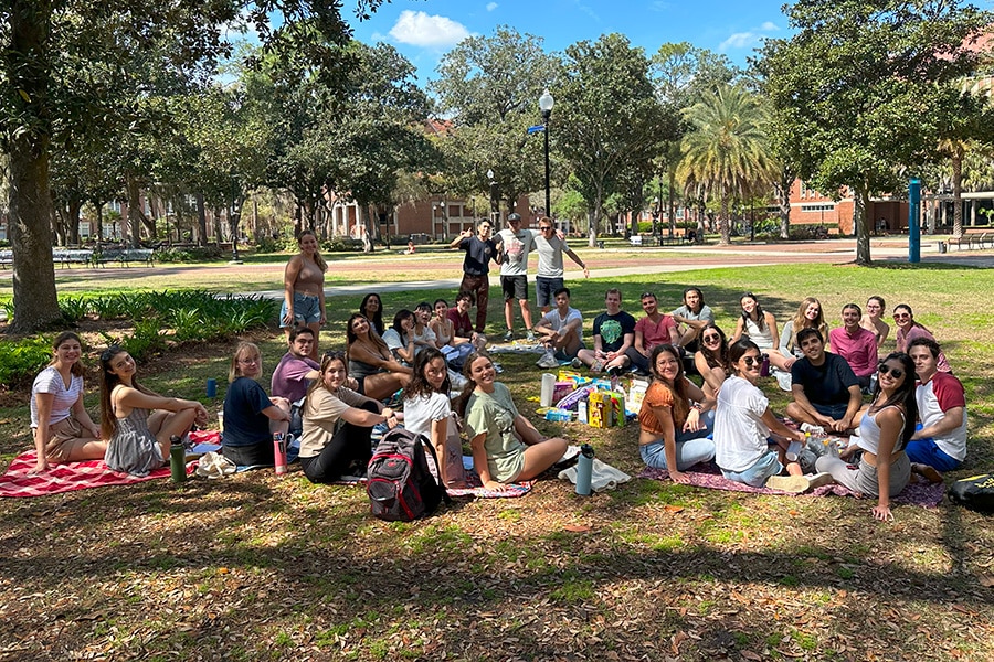 Global Business Society members sitting in the grass at Plaza of the Americas.