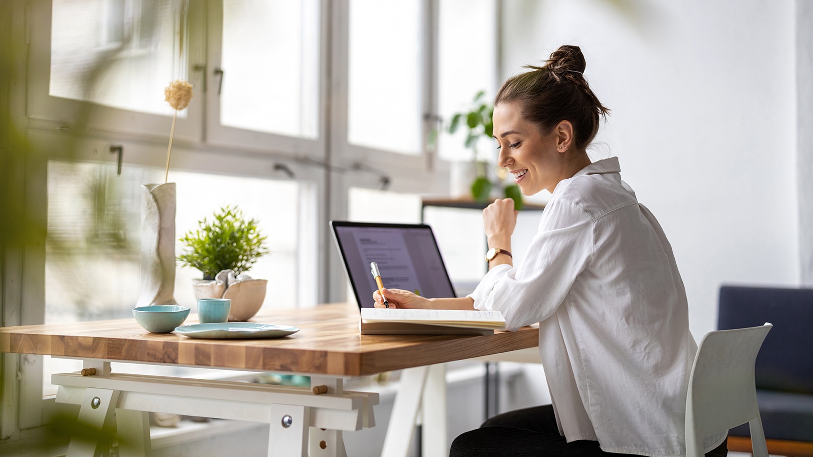 Woman with laptop smiling while working.