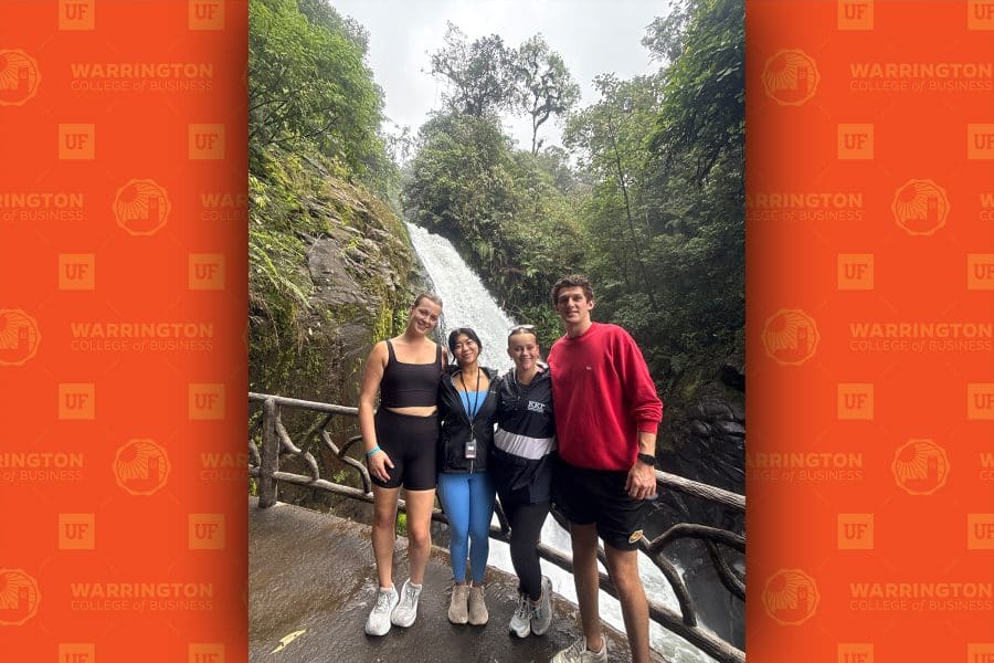 Adonis Giannopoulos standing in front of waterfall with gie team