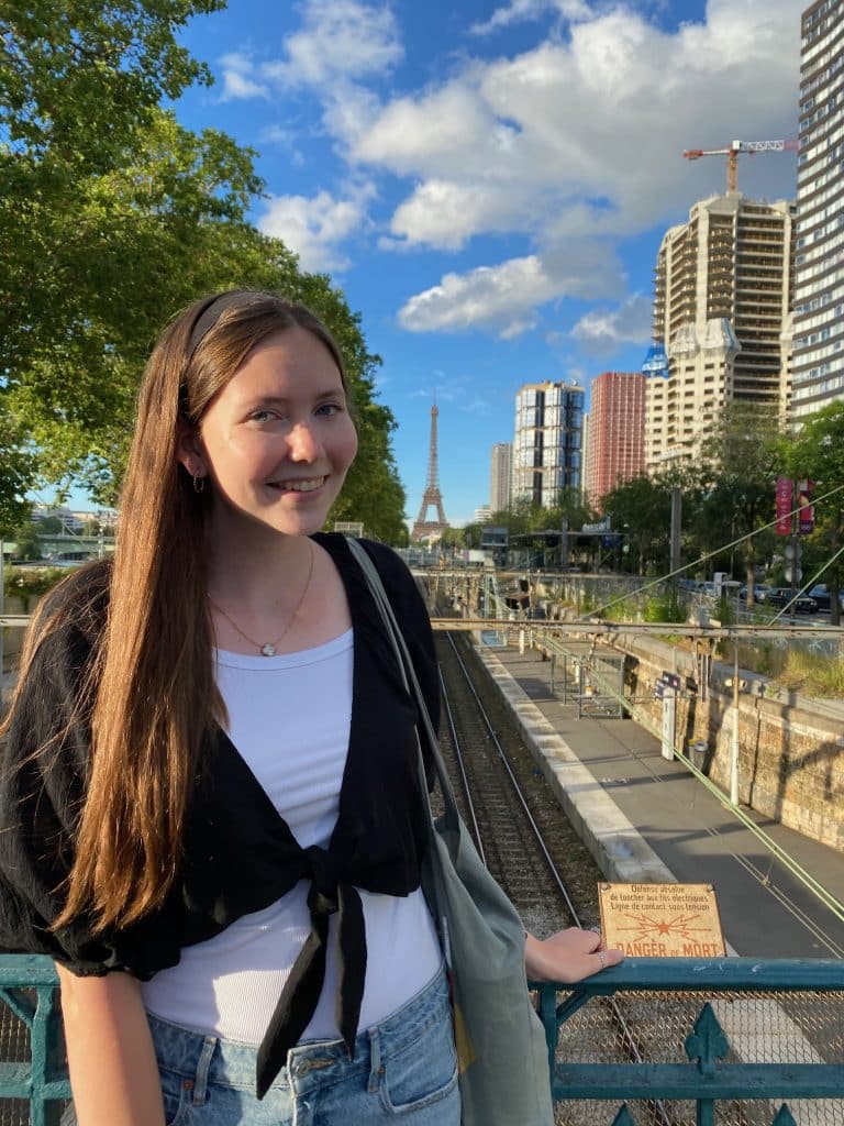 madison coble in front of city buildings and eiffel tower in paris