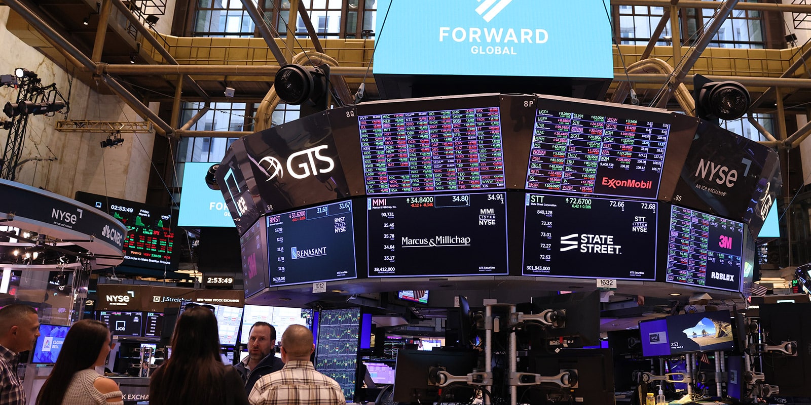 New York Stock Exchange with many screens showing stock prices and company logos