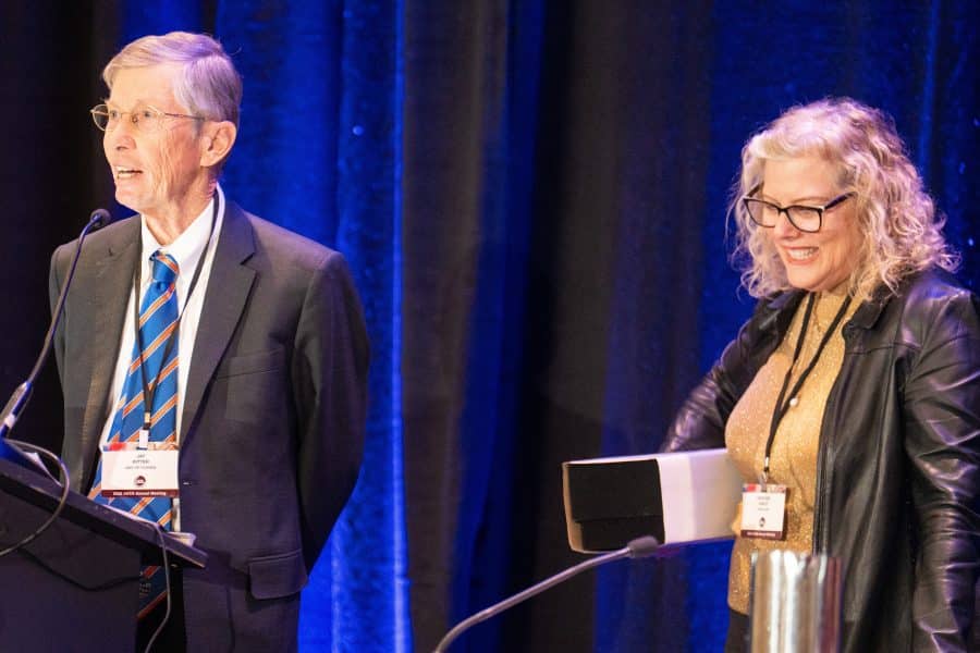 Jay Ritter stands at a podium on stage while standing next to AFA Secretary-Treasurer Kathleen Weiss Hanley.