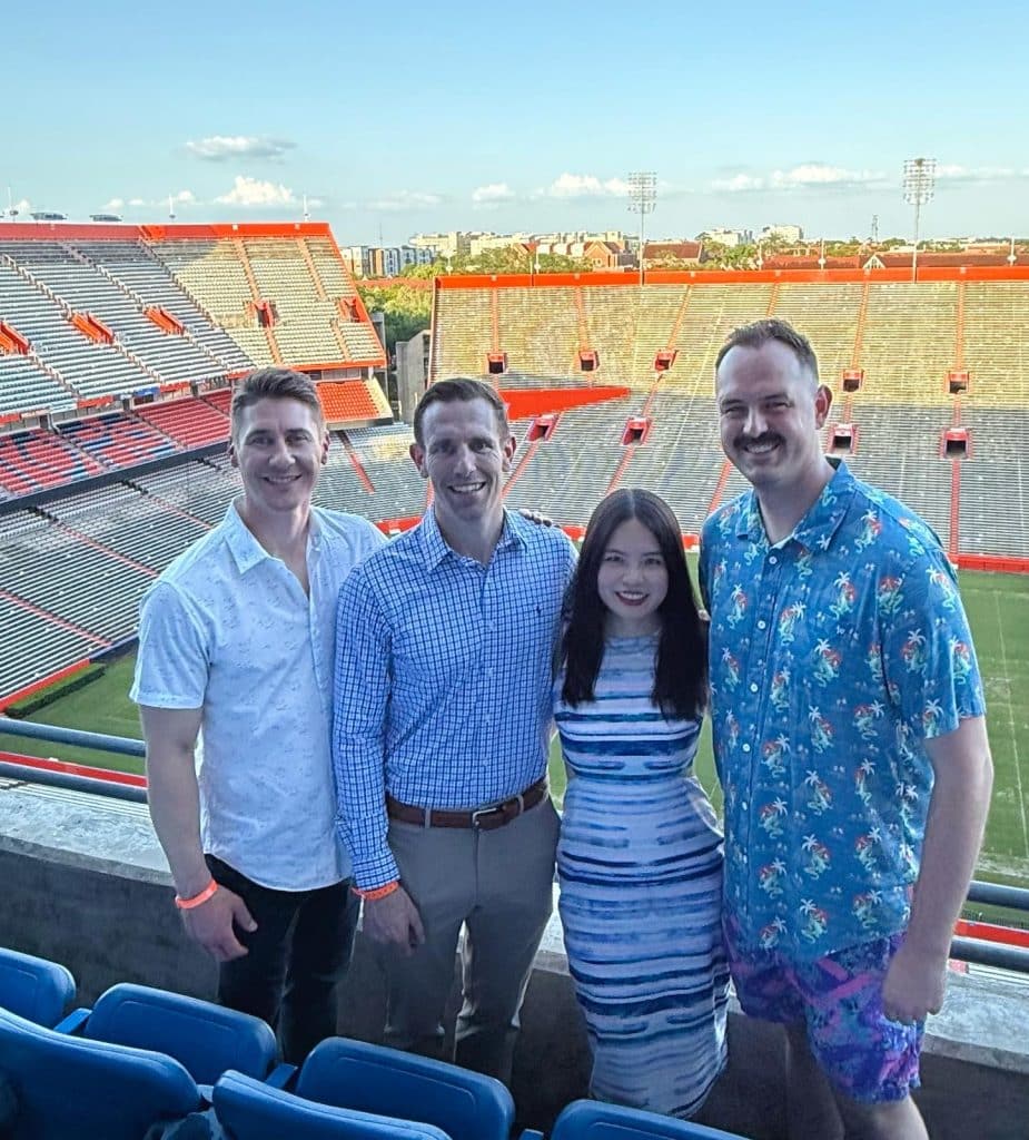 Ruijiao "Rachel" Xu poses with three fellow MBA students at the Ben Hill Griffin Stadium.