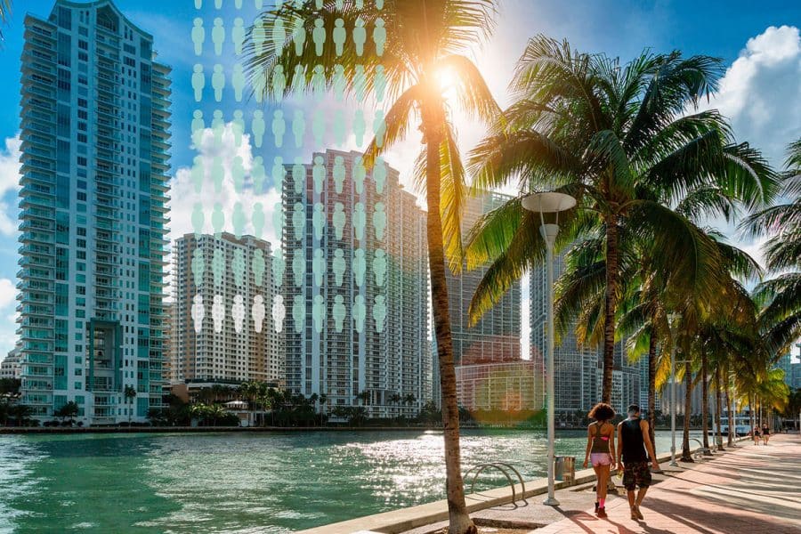 Two people walk along water by palm trees and tall buildings in the background with a population graphic overlay
