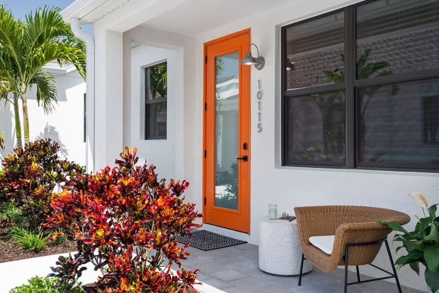 A white home with an orange front door in Odyssey by Soltura