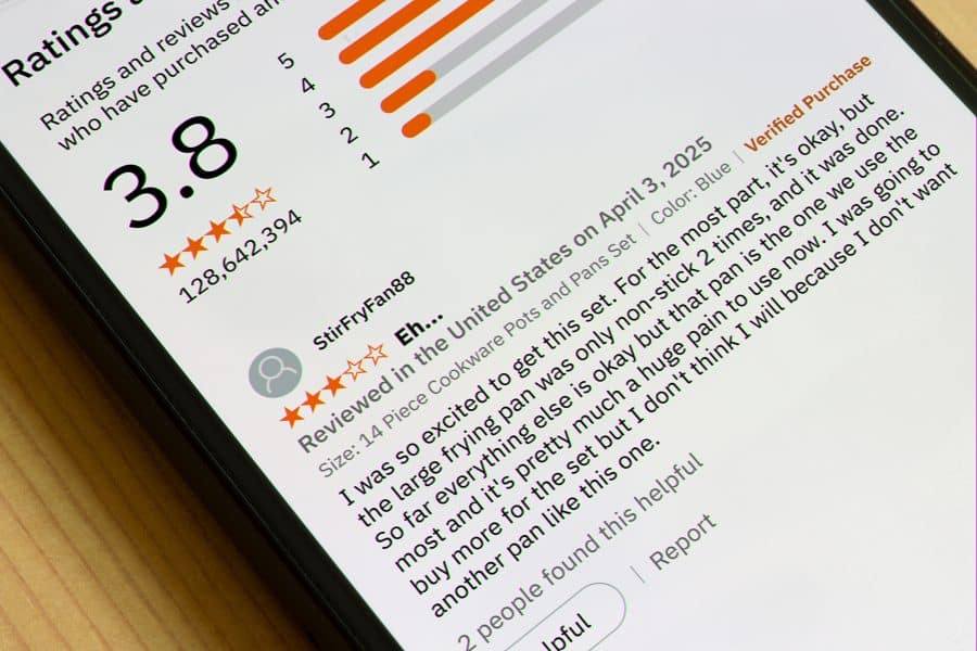 Close-up of a smartphone screen displaying a product review with a 3.8-star rating. The review expresses disappointment about a cookware set.