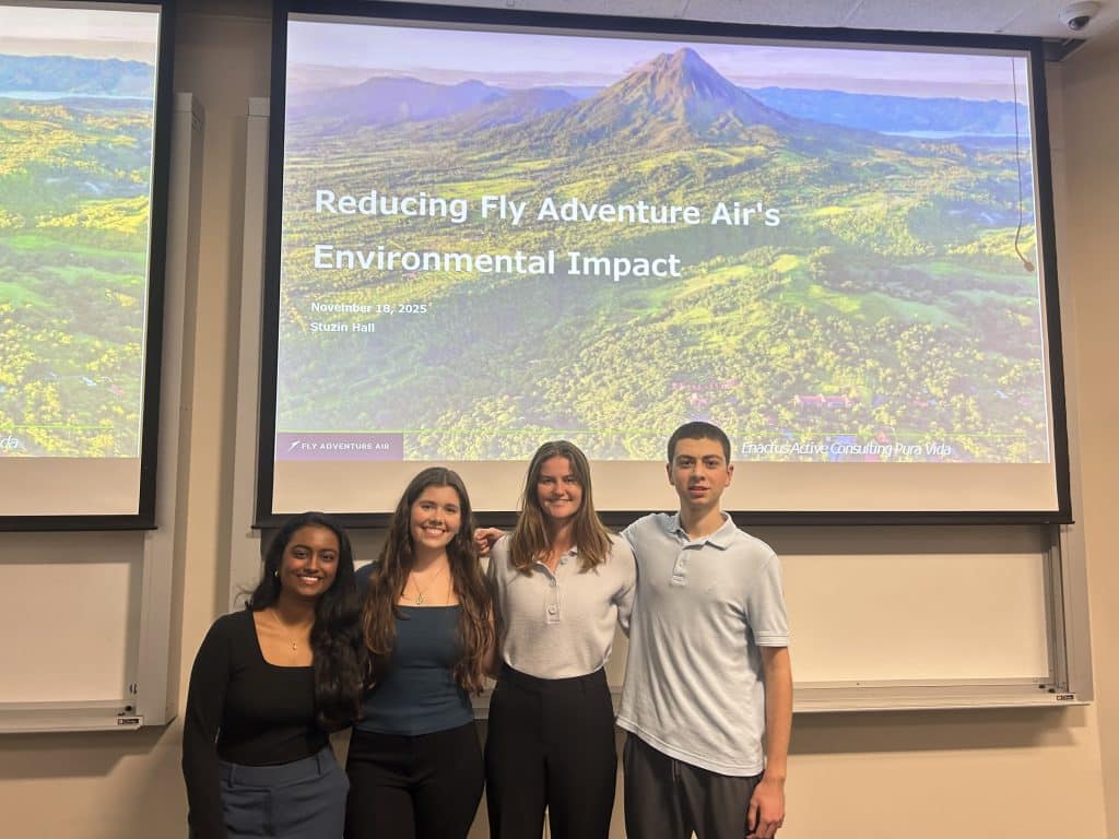 UF Enactus Consulting Project Presentation members pose in front. of a screen in November of 2025 after giving a presentation on Reducing Fly Adventure Air's Environmental Impact. 