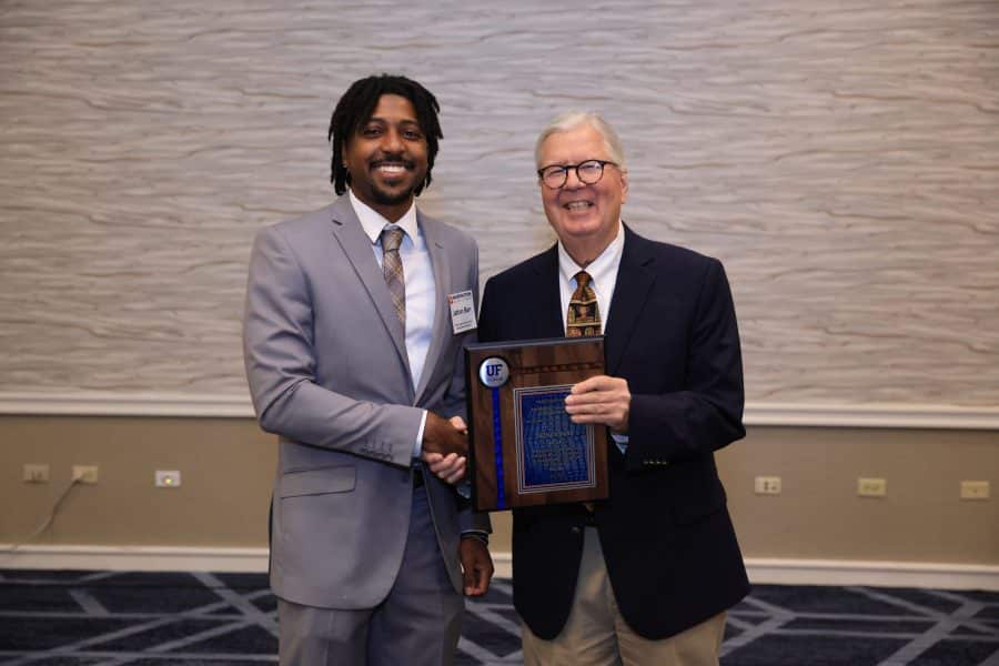 Jathan Barr poses with Gary McGill to accept his award.