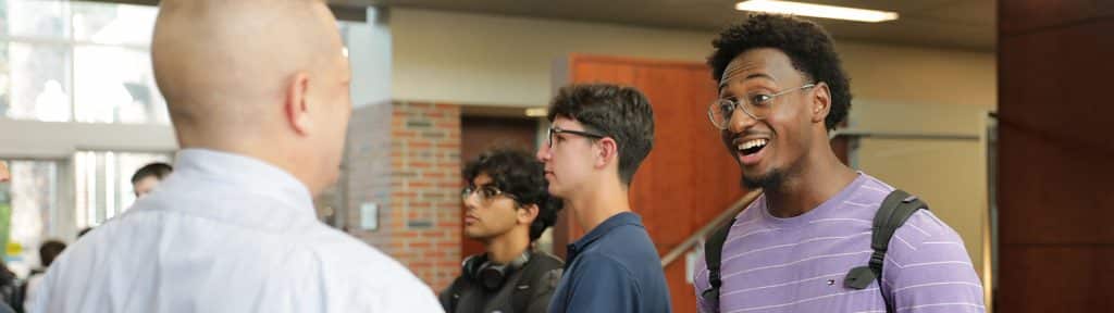 A student talking to a recruiter in the Fisher School of Accounting building.