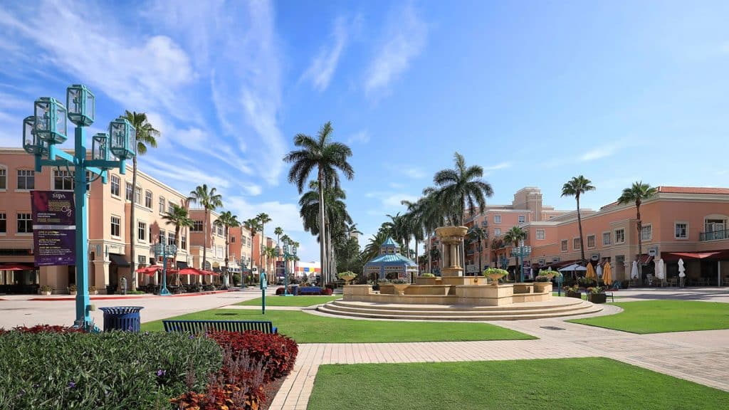 A walkable town center with shops and palm trees in a Florida city.