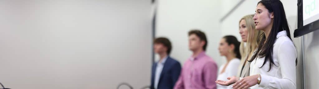 A group of students presenting in front of a board.