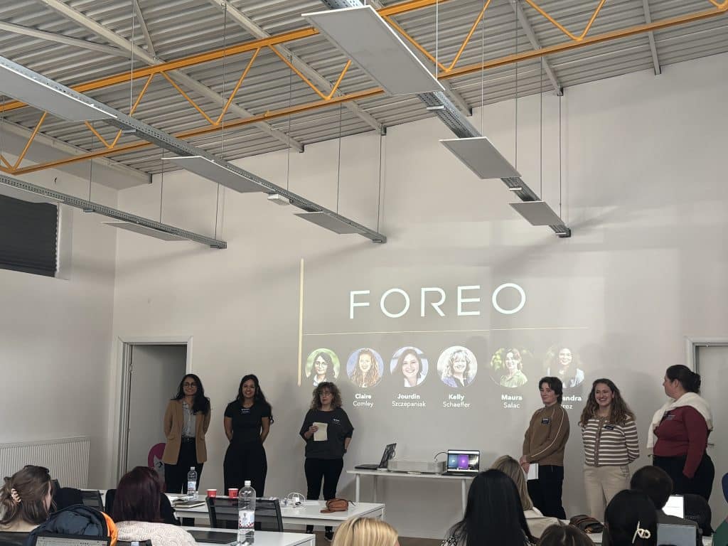 A team of MBA students present at the front of a room to the FOREO team.