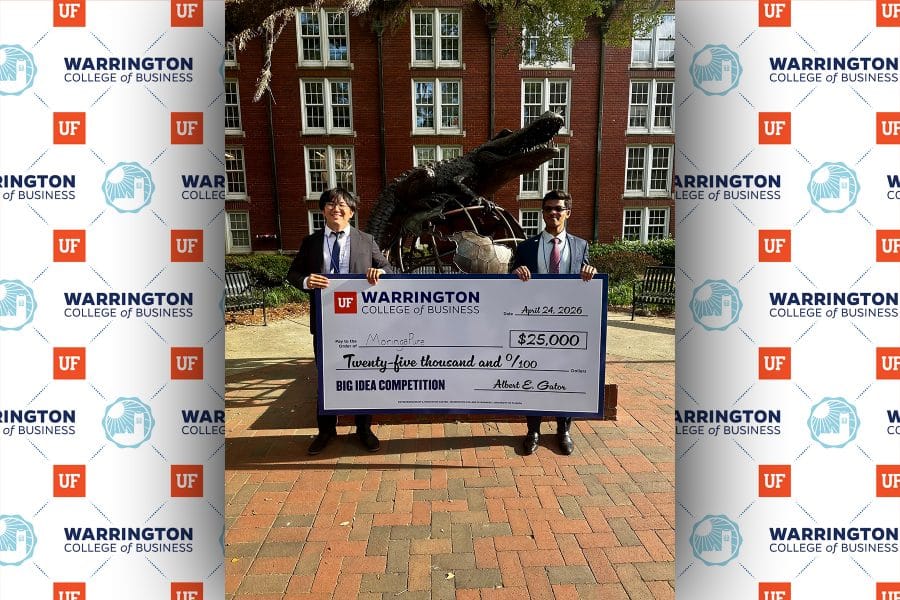 Abhith Kasala and Kallum Wang holding a $25,000 check in front of the Heavener Gator Globe