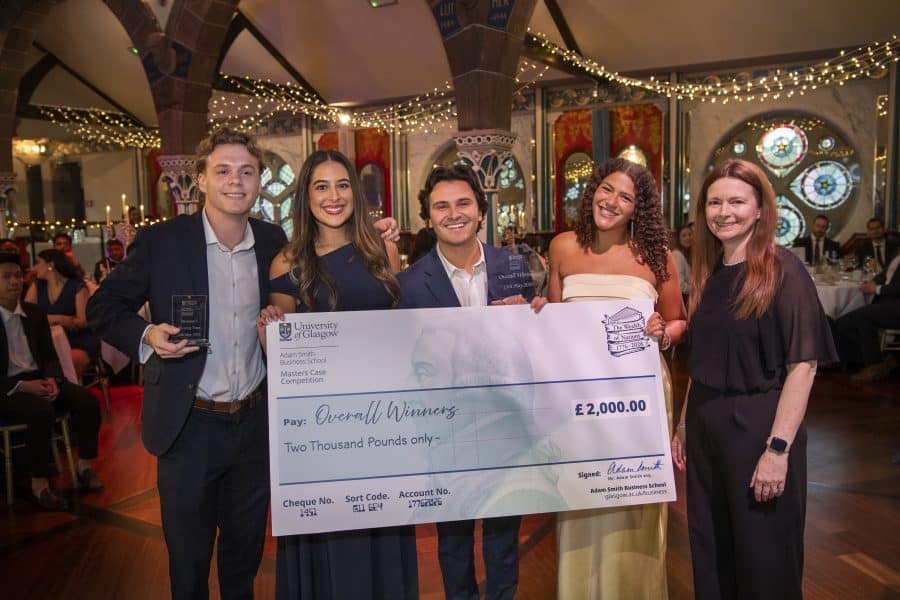 university of glasgow mib team holding a check smiling