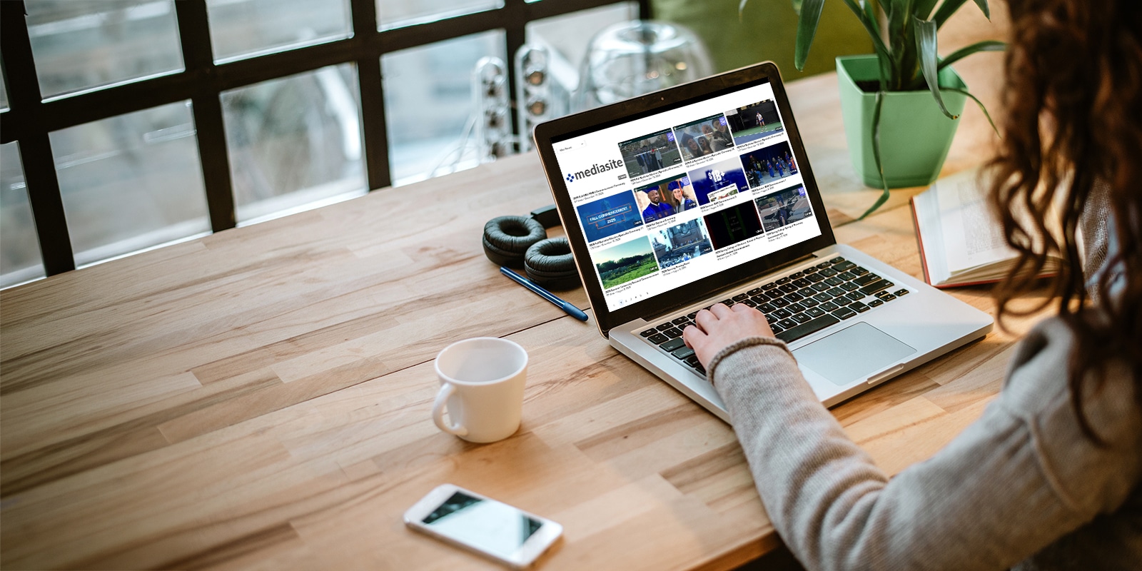 Woman browsing past graduation ceremonies on a laptop. 