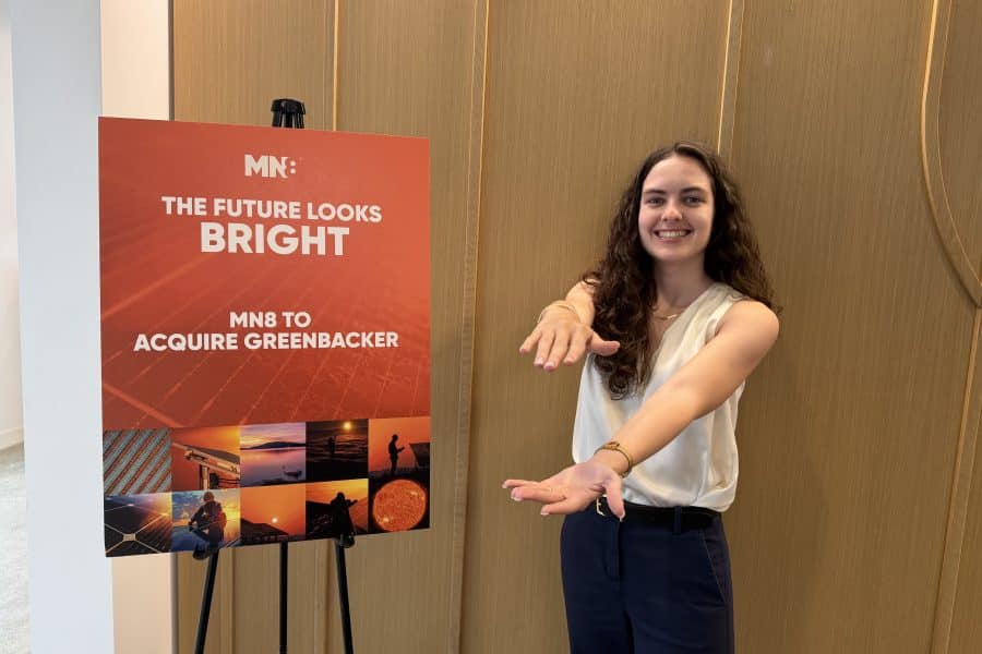Casey Foran does a Gator Chomp in front of a sign for MN8