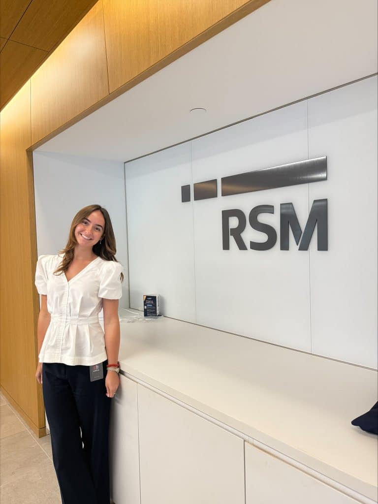 Victoria Michalski stands in front of the RSM logo.