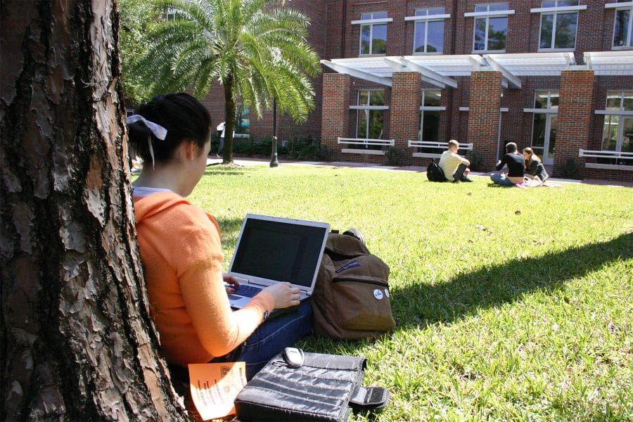 Girl sitting outside on her computer