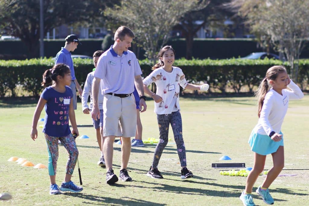 Sean Warner works with children during a Gator Junior Golf Association activity.